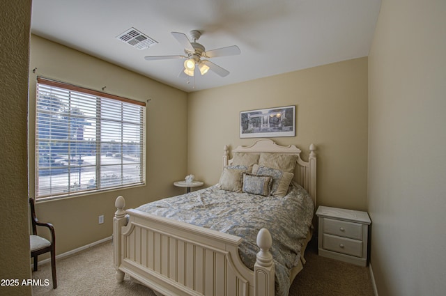 carpeted bedroom with a ceiling fan, visible vents, and baseboards