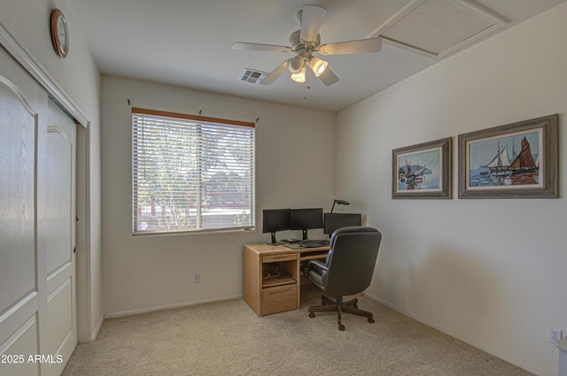 carpeted office featuring a ceiling fan, attic access, visible vents, and baseboards