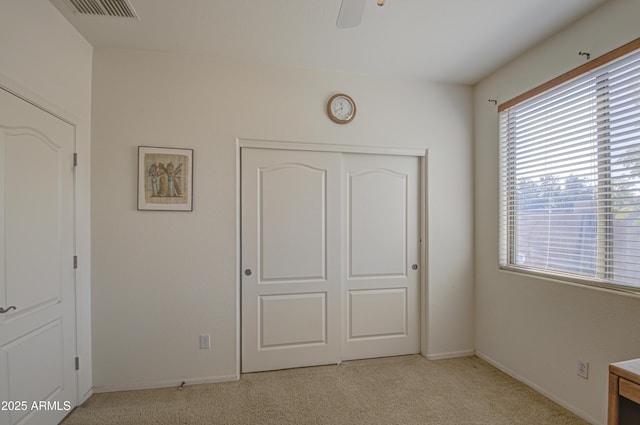 unfurnished bedroom with light carpet, baseboards, visible vents, and a closet