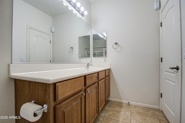 bathroom with tile patterned flooring, baseboards, and vanity