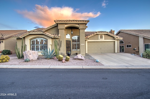 mediterranean / spanish-style home with a garage