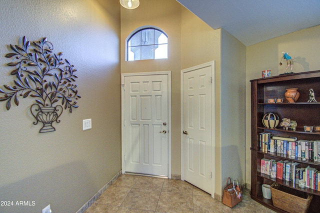 entryway featuring light tile patterned flooring and a high ceiling