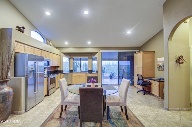 tiled dining space with vaulted ceiling and sink