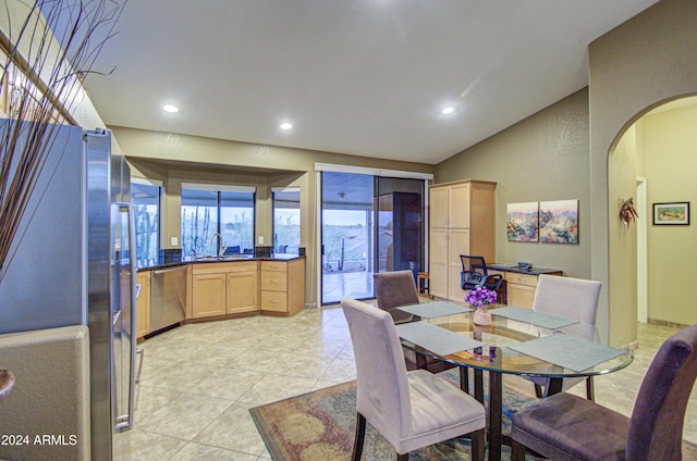 tiled dining room with sink and lofted ceiling