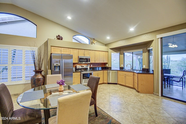 tiled dining room featuring vaulted ceiling and sink