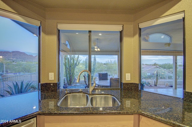 kitchen featuring dark stone countertops, a mountain view, sink, and light brown cabinets