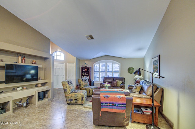 living room featuring built in shelves and vaulted ceiling