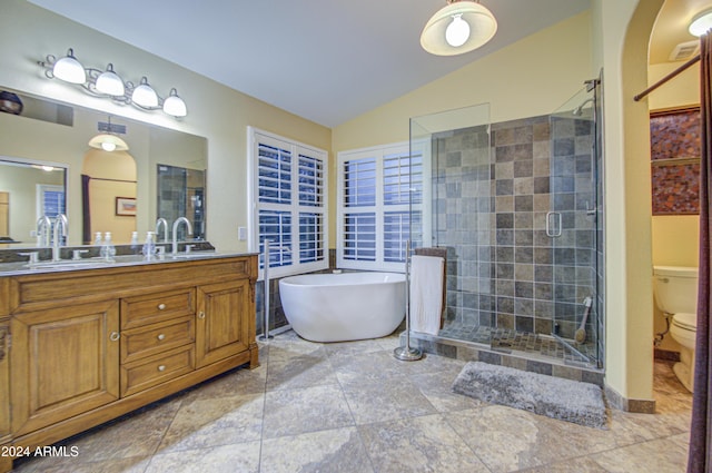 full bathroom featuring separate shower and tub, vanity, lofted ceiling, and toilet