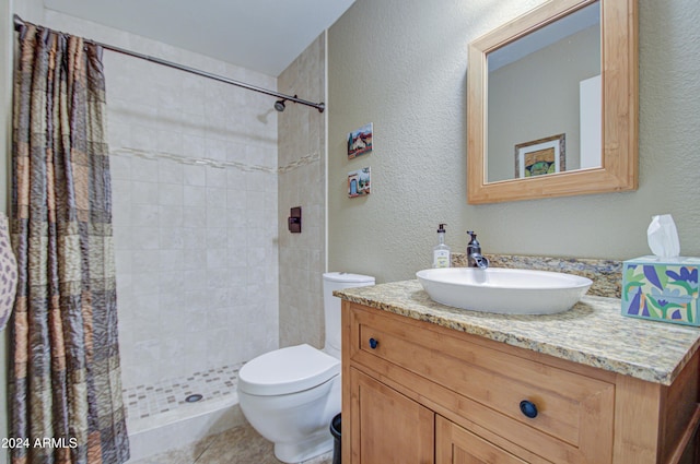 bathroom with a shower with shower curtain, vanity, toilet, and tile patterned flooring