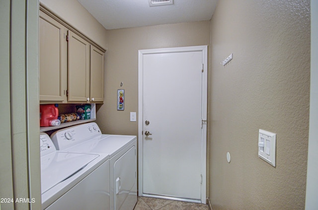 clothes washing area with washer and dryer and cabinets