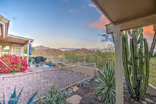 yard at dusk with a patio area and a mountain view