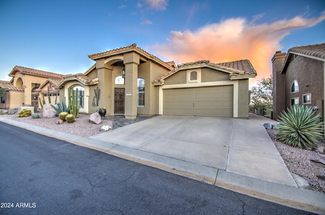 mediterranean / spanish-style house with a garage