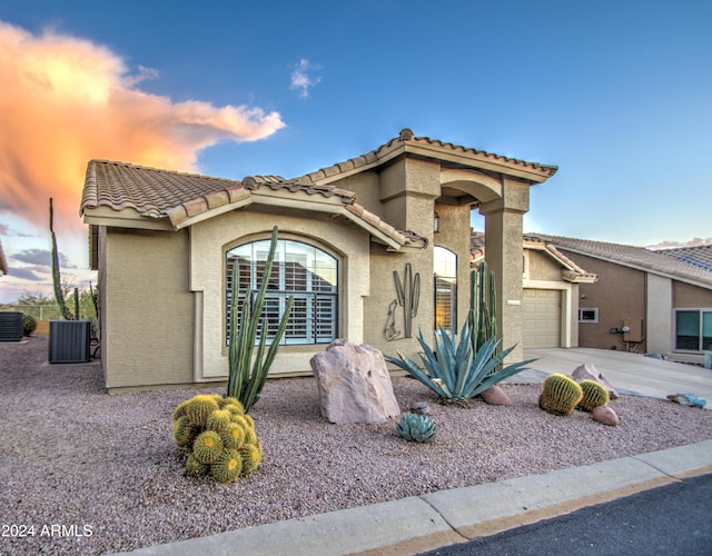 view of front of property featuring central AC unit and a garage