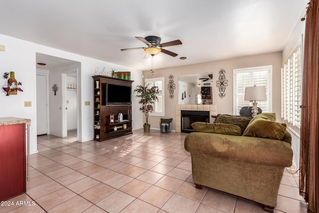 living room with ceiling fan, a fireplace, and light tile patterned floors