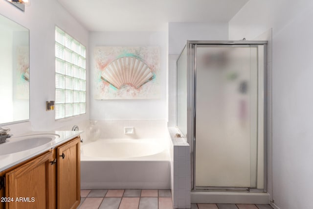 bathroom featuring tile patterned flooring, vanity, and plus walk in shower