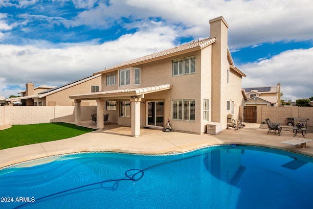 back of house featuring a pergola, a patio area, and a fenced in pool