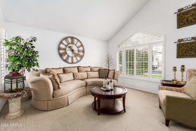 carpeted living room with high vaulted ceiling