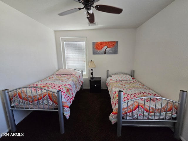 bedroom with ceiling fan and dark carpet