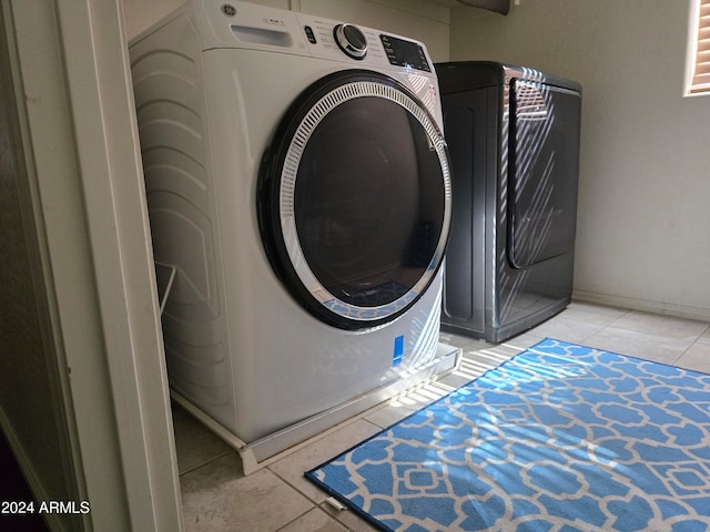 laundry area featuring light tile patterned flooring and washer / dryer