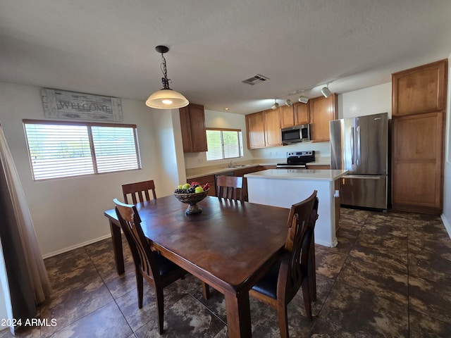 dining space featuring sink and rail lighting