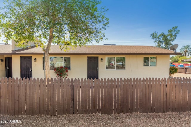 ranch-style house with fence and stucco siding