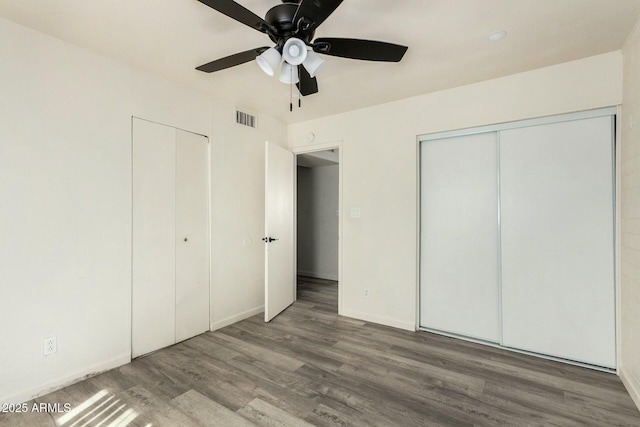 unfurnished bedroom featuring baseboards, wood finished floors, visible vents, and a ceiling fan