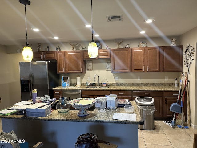 kitchen with sink, a center island, hanging light fixtures, and appliances with stainless steel finishes