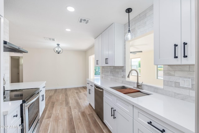 kitchen with white cabinetry, stainless steel appliances, sink, and decorative backsplash