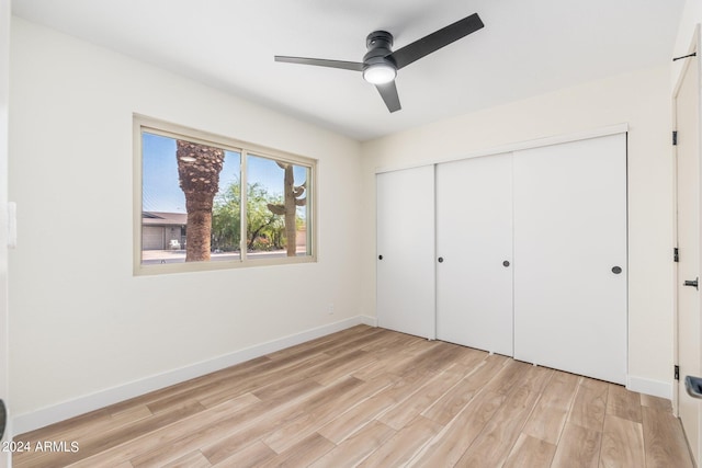 unfurnished bedroom with ceiling fan, light hardwood / wood-style floors, and a closet