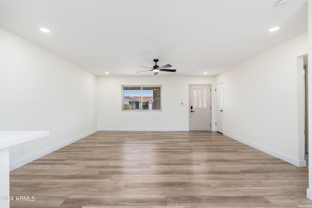 empty room with ceiling fan and light hardwood / wood-style flooring