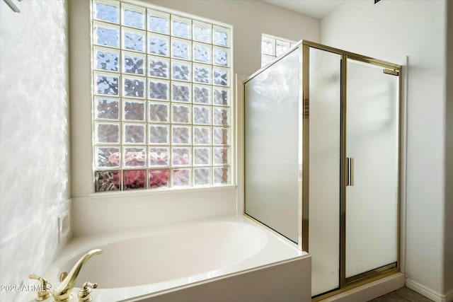 bathroom with plenty of natural light and shower with separate bathtub