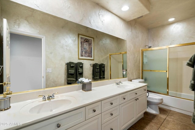 full bathroom with bath / shower combo with glass door, toilet, vanity, and tile patterned flooring