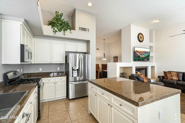 kitchen featuring white cabinetry, light tile patterned floors, stainless steel appliances, and a kitchen island