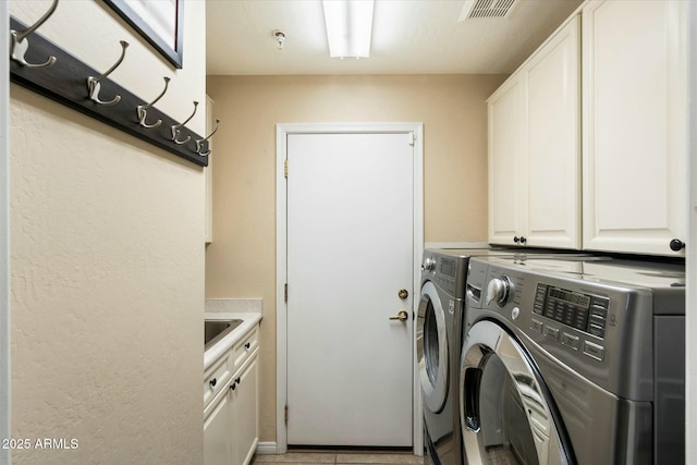 washroom with cabinets and washer and clothes dryer