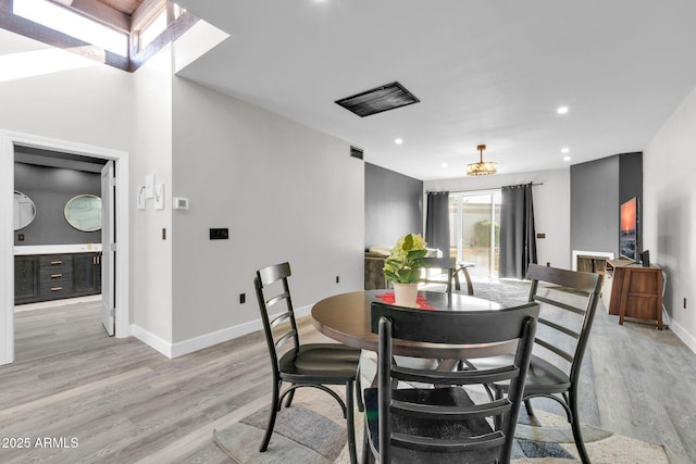 dining space featuring a skylight and light hardwood / wood-style flooring