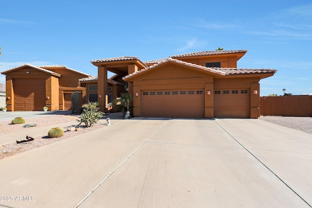 view of front of house featuring stucco siding, a tiled roof, an attached garage, and driveway