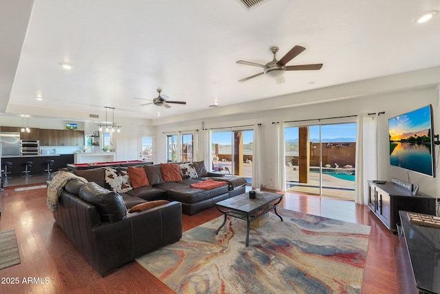 living room featuring dark hardwood / wood-style flooring and ceiling fan