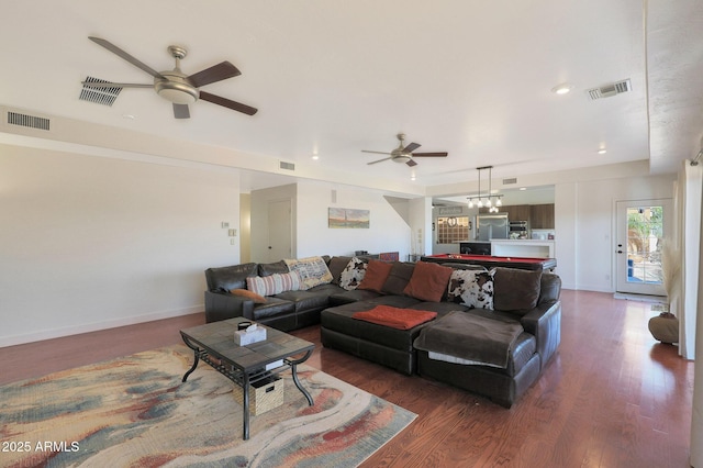 living room featuring dark wood-type flooring and ceiling fan