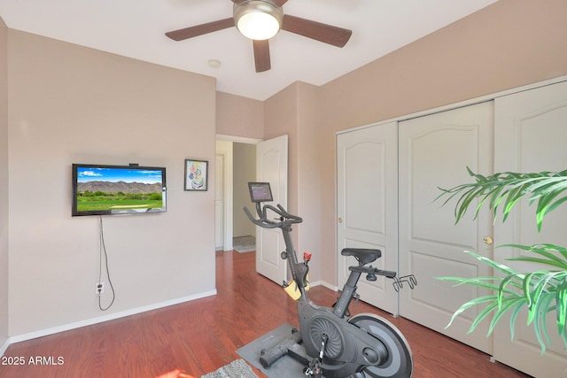 exercise area with dark wood-type flooring and ceiling fan