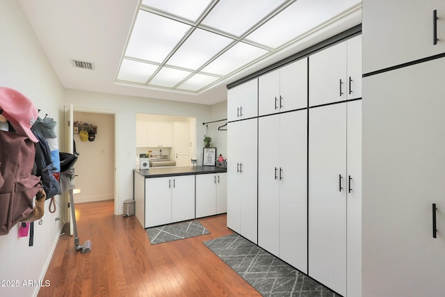 kitchen with white cabinetry, washer / clothes dryer, and dark hardwood / wood-style floors