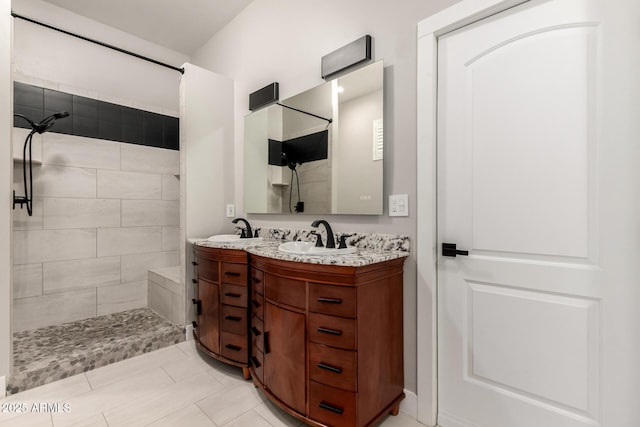 bathroom featuring vanity, tile patterned flooring, and a tile shower