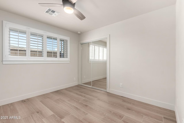 unfurnished bedroom featuring light hardwood / wood-style flooring, a closet, and ceiling fan