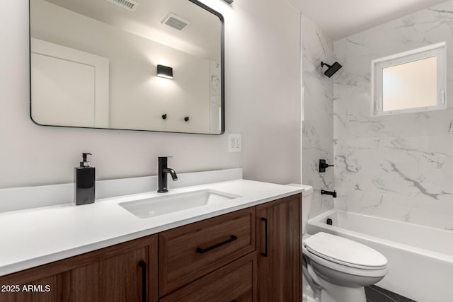 full bathroom with tiled shower / bath, vanity, and toilet