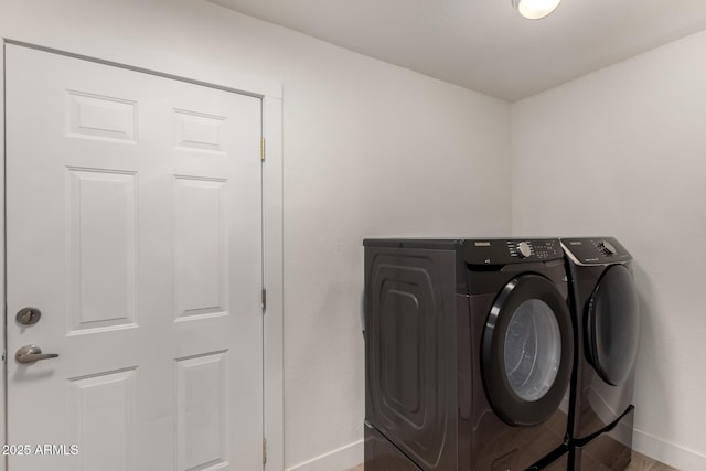 clothes washing area with hardwood / wood-style floors and washing machine and clothes dryer