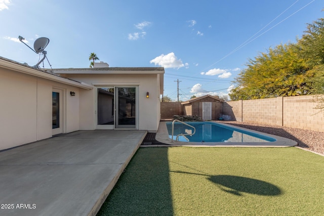 view of swimming pool featuring a patio and a shed