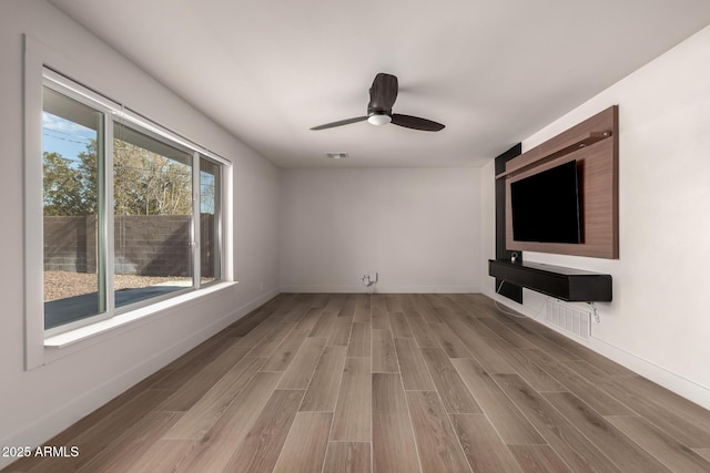 unfurnished living room with hardwood / wood-style flooring and ceiling fan