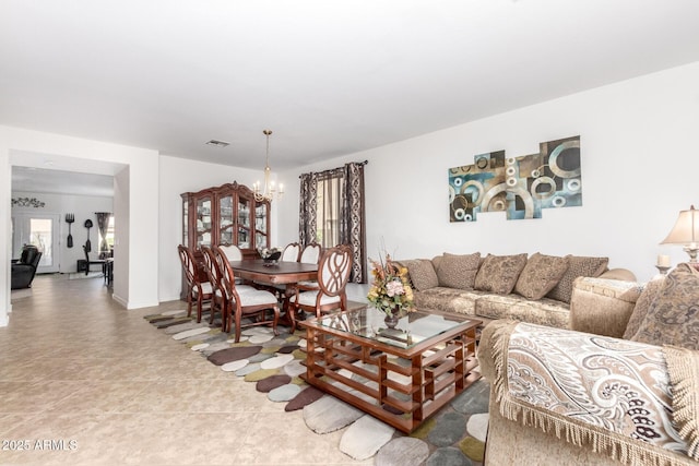 living room with tile patterned flooring and a notable chandelier