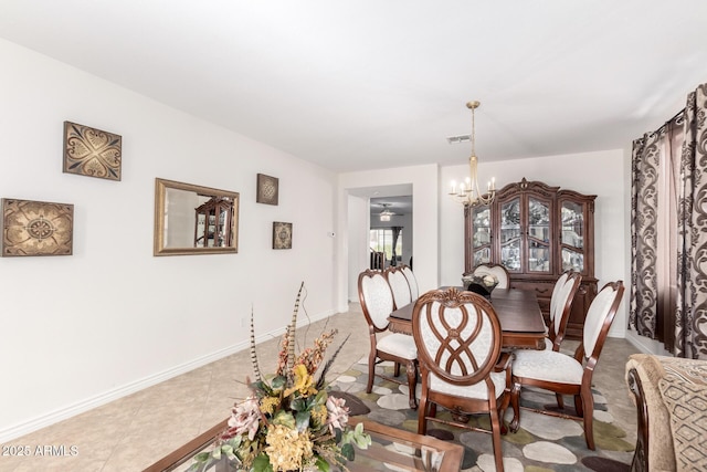 tiled dining room with a chandelier