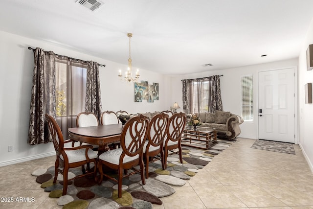 tiled dining area featuring a chandelier