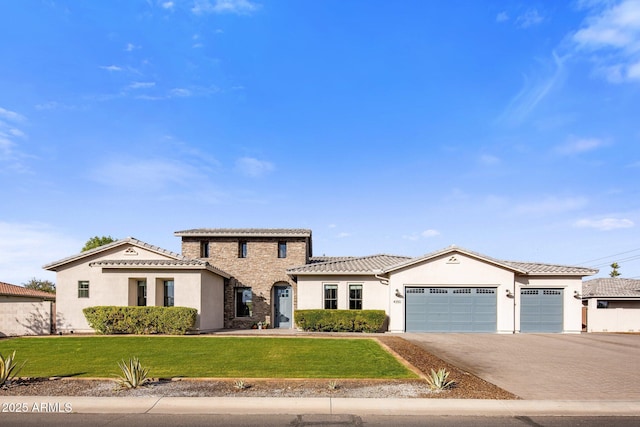 mediterranean / spanish-style house featuring a garage and a front lawn